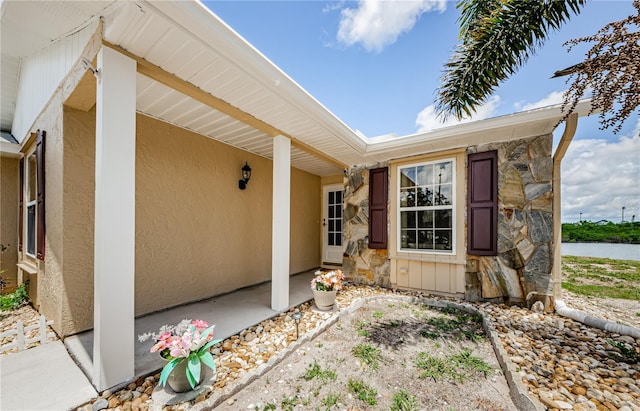 699 Merlins Ct, Tarpon Springs, FL 34689 - view of exterior entry featuring stone siding and stucco siding