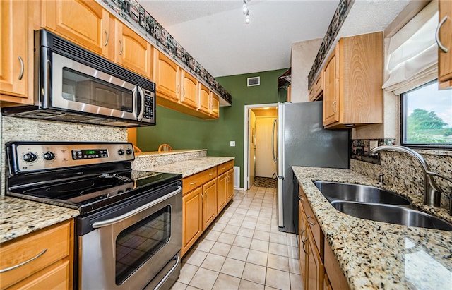 699 Merlins Ct, Tarpon Springs, FL 34689 - kitchen featuring stainless steel appliances, a sink, light stone countertops, and light tile patterned floors