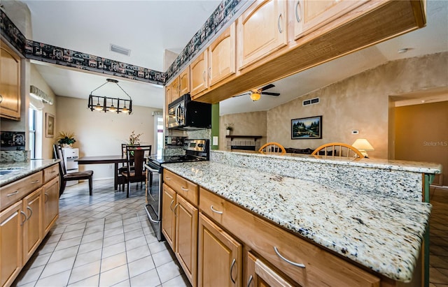 699 Merlins Ct, Tarpon Springs, FL 34689 - kitchen with stainless steel electric stove, ceiling fan, light stone counters, light tile patterned floors, and lofted ceiling
