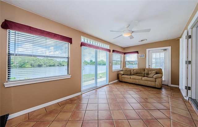 699 Merlins Ct, Tarpon Springs, FL 34689 - living room with ceiling fan, light tile patterned flooring, and baseboards
