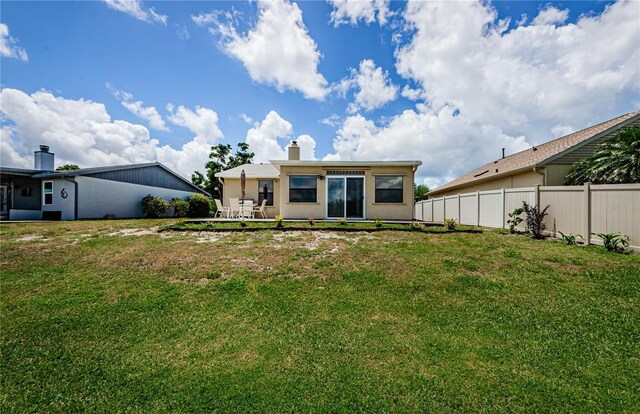 699 Merlins Ct, Tarpon Springs, FL 34689 - back of property featuring a chimney, stucco siding, and a patio