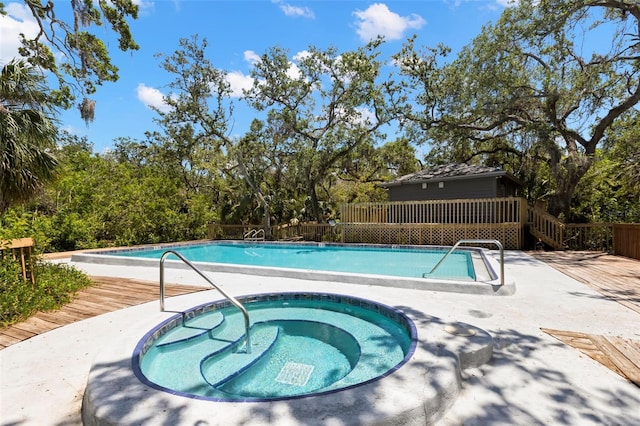 2033 Arbor Dr, Clearwater, FL 33760 - community pool featuring a hot tub, view of scattered trees, fence, and a deck