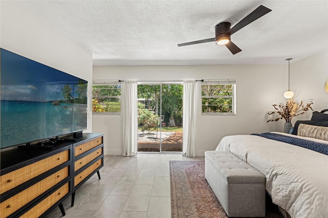 bedroom featuring access to exterior, a textured ceiling, a ceiling fan, light tile patterned floors, and baseboards