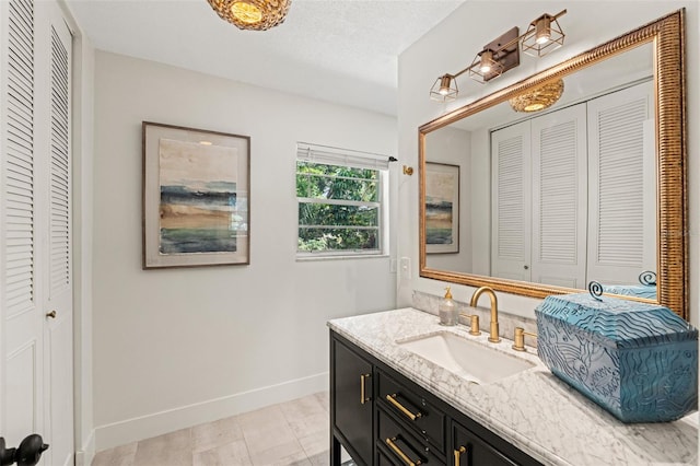 bathroom featuring a closet, baseboards, and vanity
