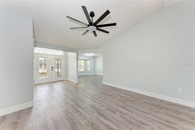 3330 46th Ter E, Bradenton, FL 34203 - unfurnished living room featuring lofted ceiling, wood finished floors, ceiling fan, french doors, and baseboards
