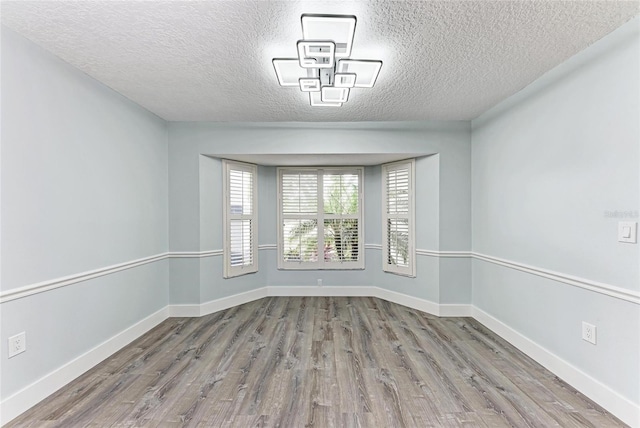 3330 46th Ter E, Bradenton, FL 34203 - spare room with wood finished floors, a textured ceiling, and baseboards