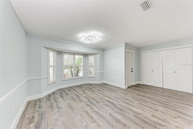 3330 46th Ter E, Bradenton, FL 34203 - unfurnished bedroom featuring wood finished floors, a textured ceiling, baseboards, and a closet