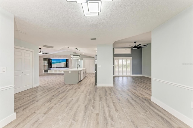 3330 46th Ter E, Bradenton, FL 34203 - unfurnished living room with ceiling fan, light wood finished floors, a sink, baseboards, and a textured ceiling