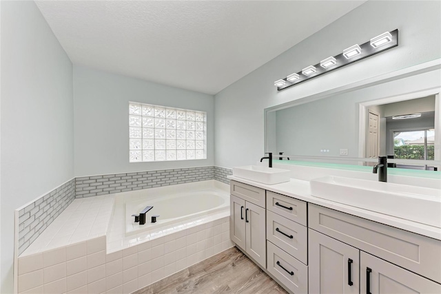 3330 46th Ter E, Bradenton, FL 34203 - bathroom featuring double vanity, a garden tub, and wood finished floors