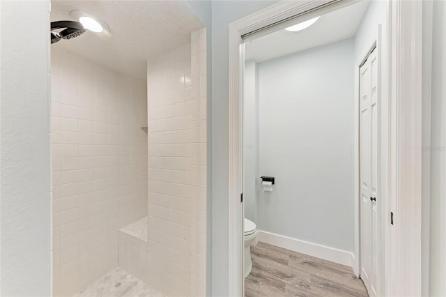 3330 46th Ter E, Bradenton, FL 34203 - bathroom with wood finished floors, toilet, a tile shower, and baseboards