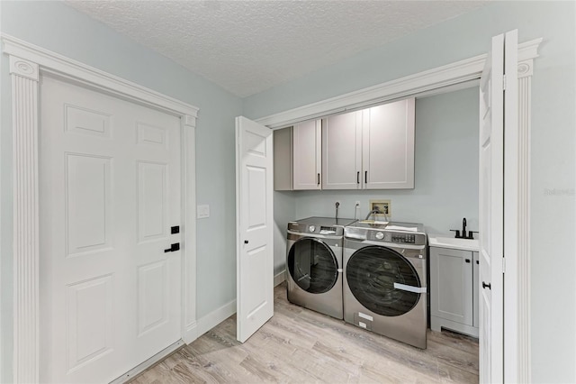 3330 46th Ter E, Bradenton, FL 34203 - laundry room featuring cabinet space, washer and dryer, light wood-style flooring, and a textured ceiling