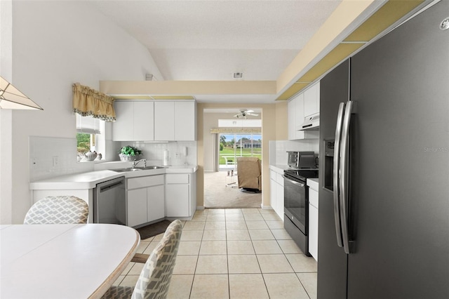 9188 Rhett Ln, Weeki Wachee, FL 34613 - kitchen with stainless steel appliances, light countertops, tasteful backsplash, white cabinets, and under cabinet range hood