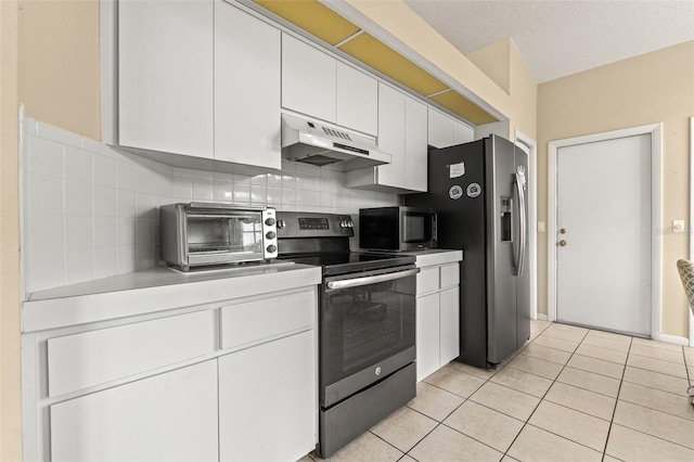 9188 Rhett Ln, Weeki Wachee, FL 34613 - kitchen featuring under cabinet range hood, stainless steel appliances, white cabinets, tasteful backsplash, and light tile patterned flooring