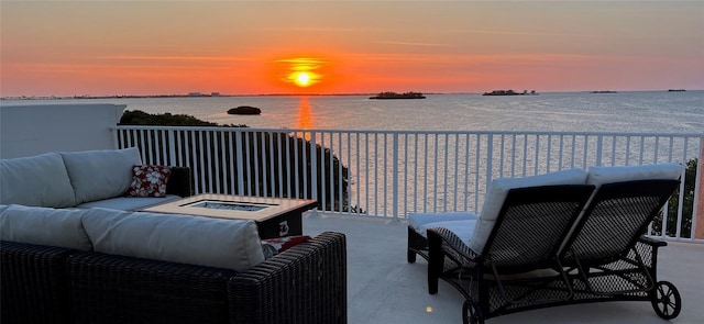 2750 Reserve Ct Unit 101, Dunedin, FL 34698 - patio terrace at dusk with an outdoor living space with a fire pit, a balcony, and a water view