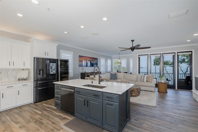 2750 Reserve Ct Unit 101, Dunedin, FL 34698 - kitchen featuring refrigerator with ice dispenser, dishwasher, white cabinetry, a sink, and crown molding