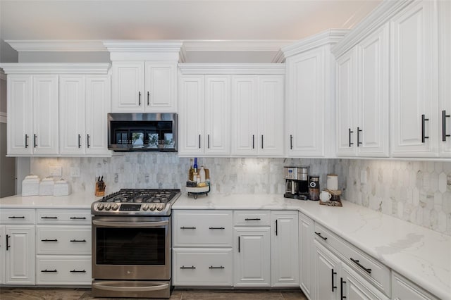2750 Reserve Ct Unit 101, Dunedin, FL 34698 - kitchen with stainless steel appliances, white cabinets, and crown molding
