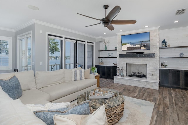 2750 Reserve Ct Unit 101, Dunedin, FL 34698 - living area featuring plenty of natural light, wood finished floors, a ceiling fan, crown molding, and a fireplace