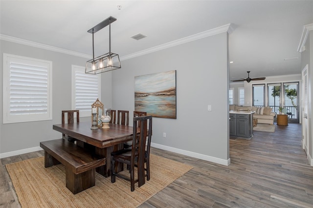 2750 Reserve Ct Unit 101, Dunedin, FL 34698 - dining room featuring baseboards, wood finished floors, crown molding, and a ceiling fan