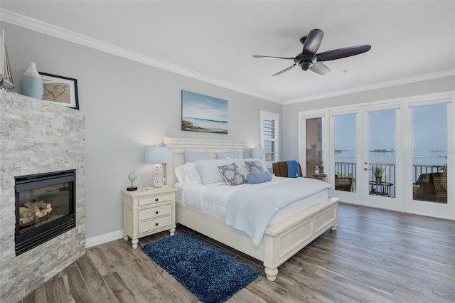 2750 Reserve Ct Unit 101, Dunedin, FL 34698 - bedroom featuring access to outside, ornamental molding, wood finished floors, a stone fireplace, and baseboards