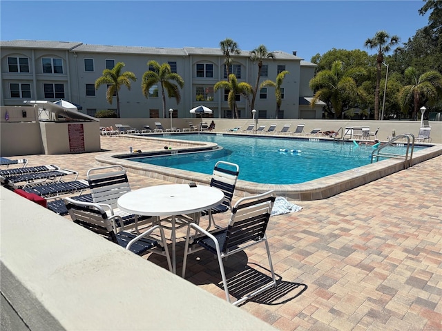 2750 Reserve Ct Unit 101, Dunedin, FL 34698 - community pool with a patio, fence, and an outdoor kitchen