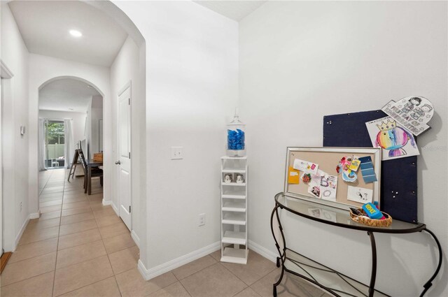 32965 Kaloko Rd, Wesley Chapel, FL 33543 - hallway with arched walkways, tile patterned floors, and baseboards
