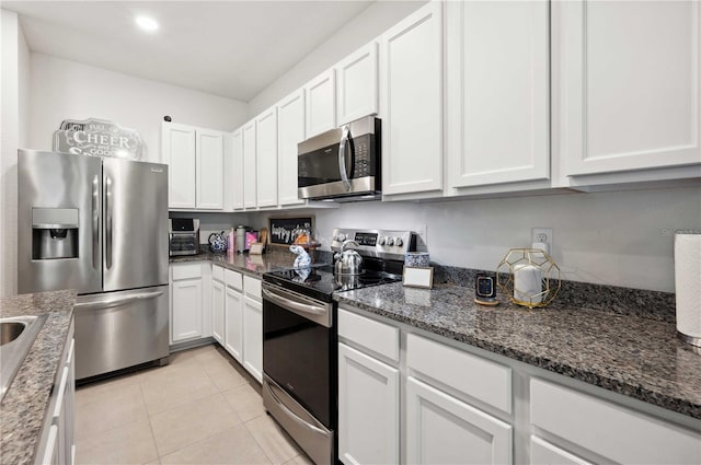 32965 Kaloko Rd, Wesley Chapel, FL 33543 - kitchen featuring appliances with stainless steel finishes, white cabinets, dark stone counters, light tile patterned flooring, and recessed lighting
