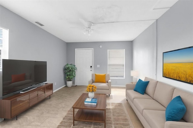 living area with ceiling fan and baseboards