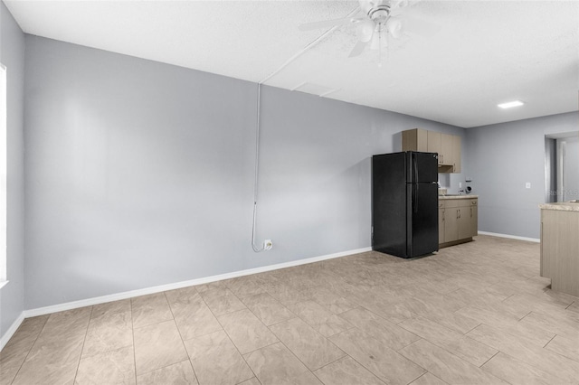 unfurnished living room featuring baseboards and a ceiling fan