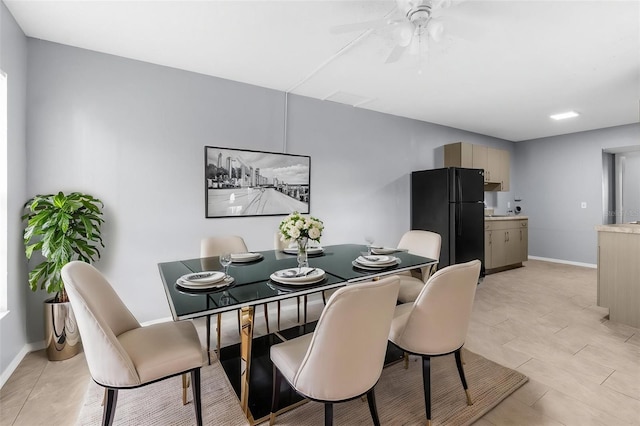 dining area with baseboards and ceiling fan