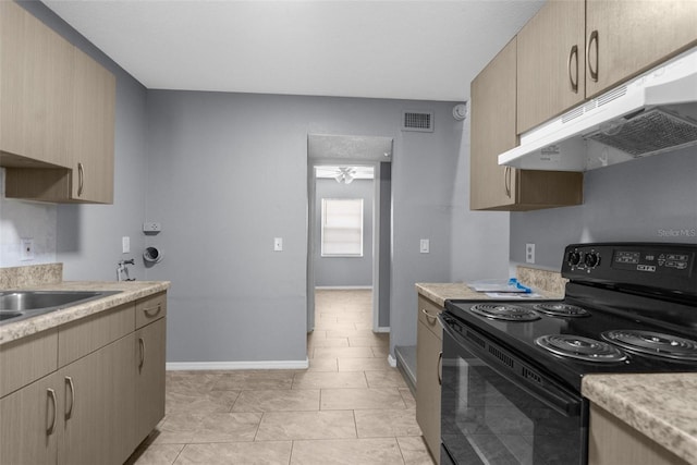 kitchen with black / electric stove, under cabinet range hood, light countertops, and baseboards