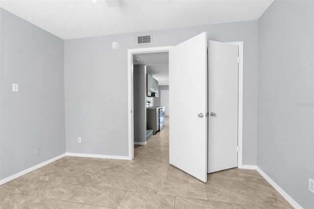 empty room featuring baseboards and a textured ceiling