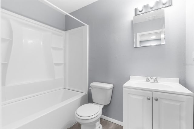 bathroom featuring toilet, vanity, tub / shower combination, and baseboards