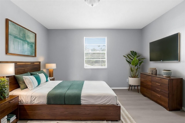 bedroom featuring light wood-style floors and baseboards