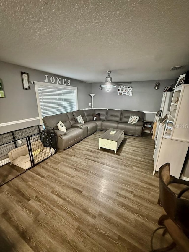 10411 Summerview Cir, Riverview, FL 33578 - living area with wood finished floors, a textured ceiling, a ceiling fan, and baseboards