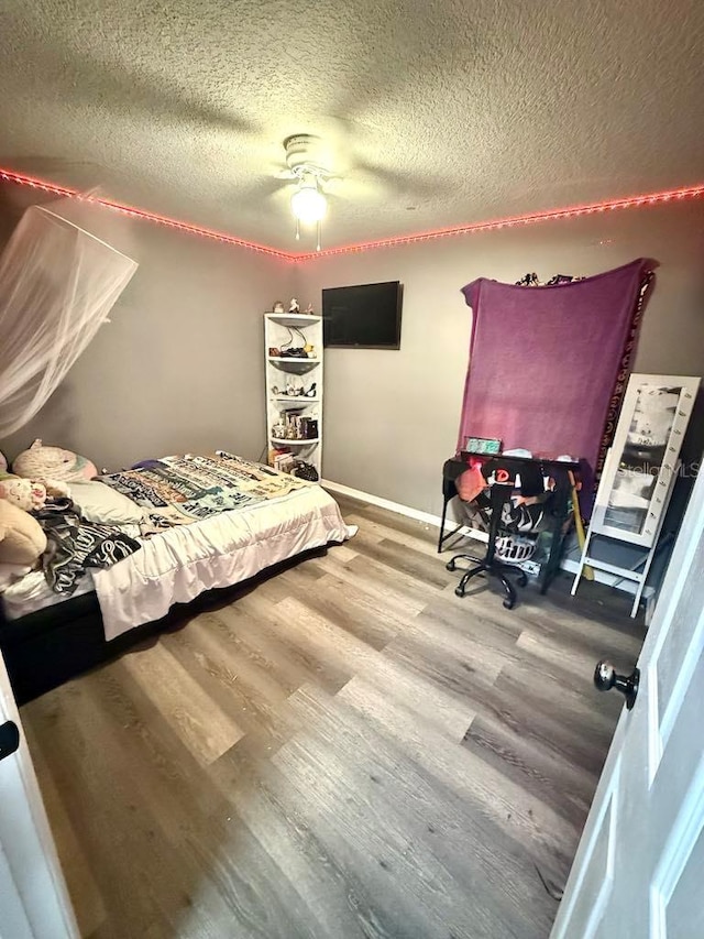 10411 Summerview Cir, Riverview, FL 33578 - bedroom with a textured ceiling, wood finished floors, a ceiling fan, and baseboards