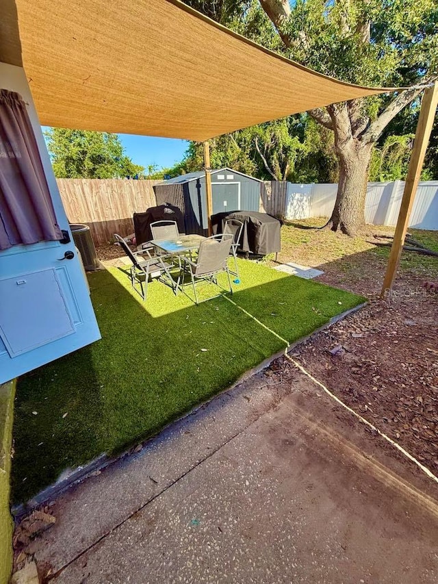 10411 Summerview Cir, Riverview, FL 33578 - view of yard with a storage unit, an outdoor structure, a patio area, and central AC