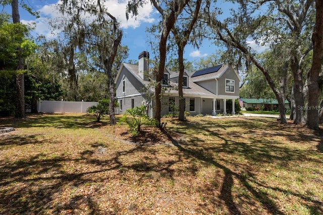 11207 Donneymoor Dr, Riverview, FL 33569 - rear view of property with a chimney and solar panels