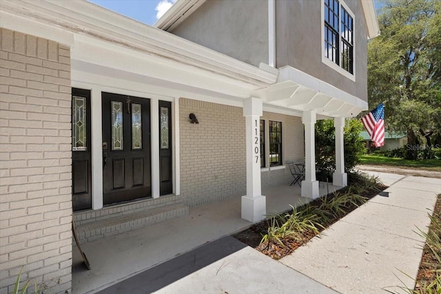 11207 Donneymoor Dr, Riverview, FL 33569 - doorway to property with covered porch and brick siding