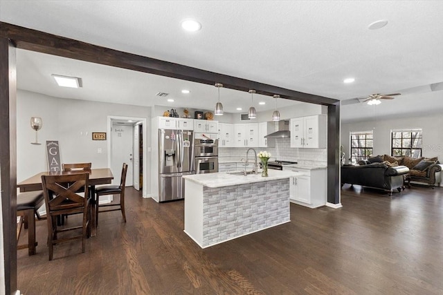 11207 Donneymoor Dr, Riverview, FL 33569 - kitchen with appliances with stainless steel finishes, wall chimney exhaust hood, dark wood-style floors, beamed ceiling, and a sink