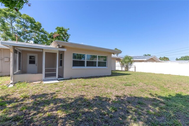 1400 63rd Ave S, Saint Petersburg, FL 33705 - rear view of property with stucco siding and a sunroom