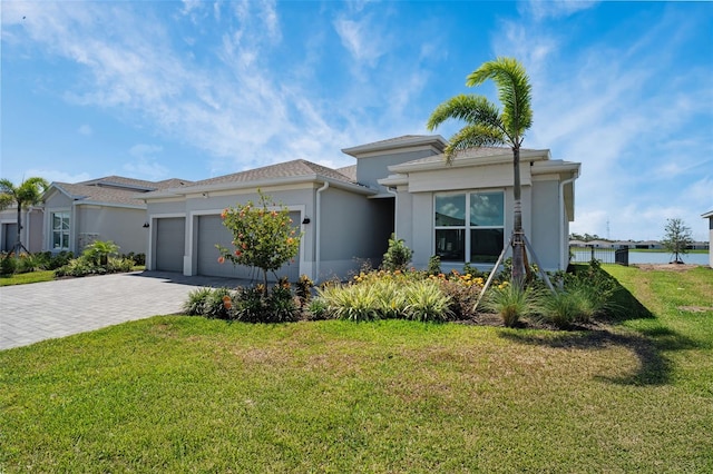 8589 Saint Kitts Cir, Englewood, FL 34224 - prairie-style home featuring a garage, decorative driveway, stucco siding, and a front yard