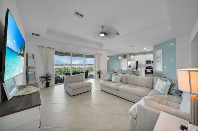 8589 Saint Kitts Cir, Englewood, FL 34224 - living area featuring a ceiling fan, light tile patterned floors, and a raised ceiling