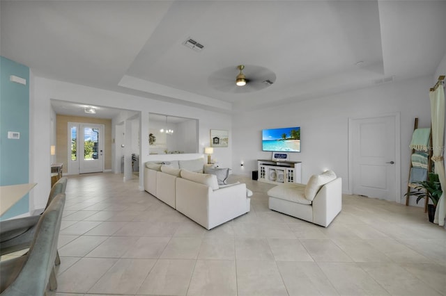 8589 Saint Kitts Cir, Englewood, FL 34224 - living room featuring a tray ceiling, light tile patterned floors, and a ceiling fan