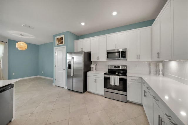 8589 Saint Kitts Cir, Englewood, FL 34224 - kitchen with appliances with stainless steel finishes, tasteful backsplash, light countertops, white cabinets, and recessed lighting