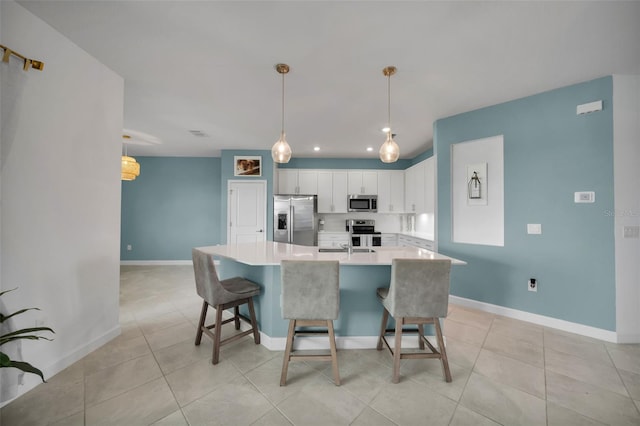 8589 Saint Kitts Cir, Englewood, FL 34224 - kitchen with appliances with stainless steel finishes, white cabinets, light countertops, a kitchen island with sink, and light tile patterned flooring