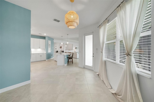 8589 Saint Kitts Cir, Englewood, FL 34224 - hall featuring plenty of natural light, light tile patterned floors, and baseboards