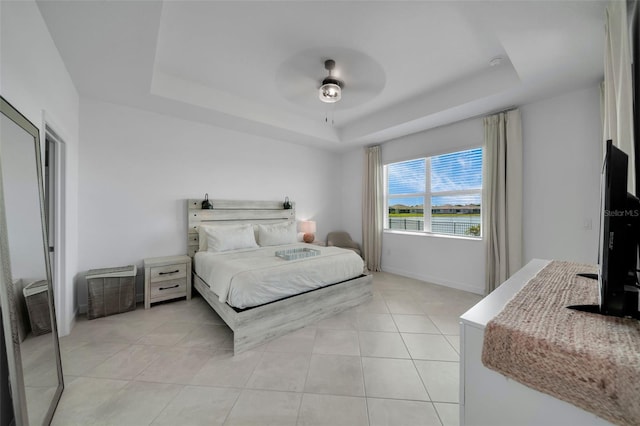 8589 Saint Kitts Cir, Englewood, FL 34224 - bedroom featuring a tray ceiling, light tile patterned flooring, a ceiling fan, and baseboards