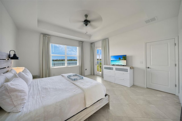 8589 Saint Kitts Cir, Englewood, FL 34224 - bedroom featuring a tray ceiling, light tile patterned floors, a ceiling fan, and baseboards