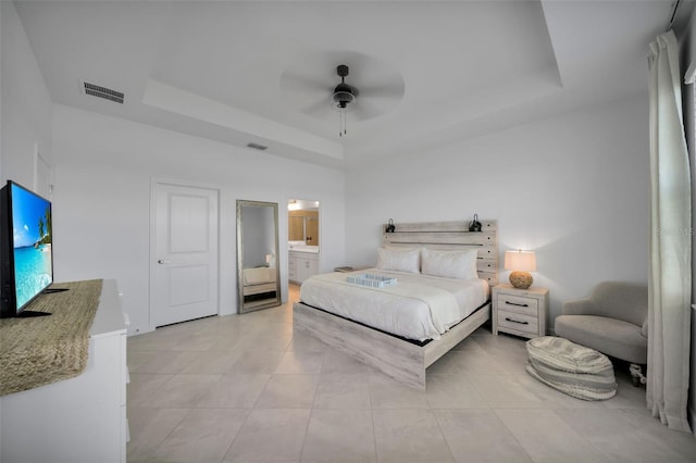 8589 Saint Kitts Cir, Englewood, FL 34224 - bedroom featuring a tray ceiling, light tile patterned floors, a ceiling fan, and ensuite bath
