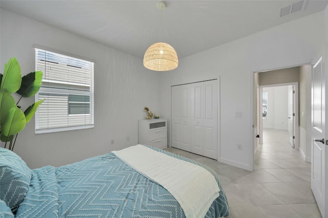 8589 Saint Kitts Cir, Englewood, FL 34224 - bedroom with light tile patterned floors, a closet, and baseboards